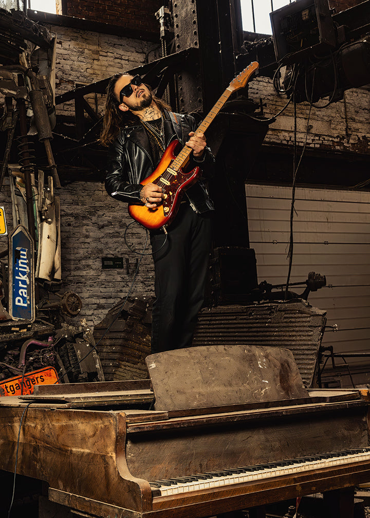 Musician holding Crafter SVVSM TS guitar in industrial setting