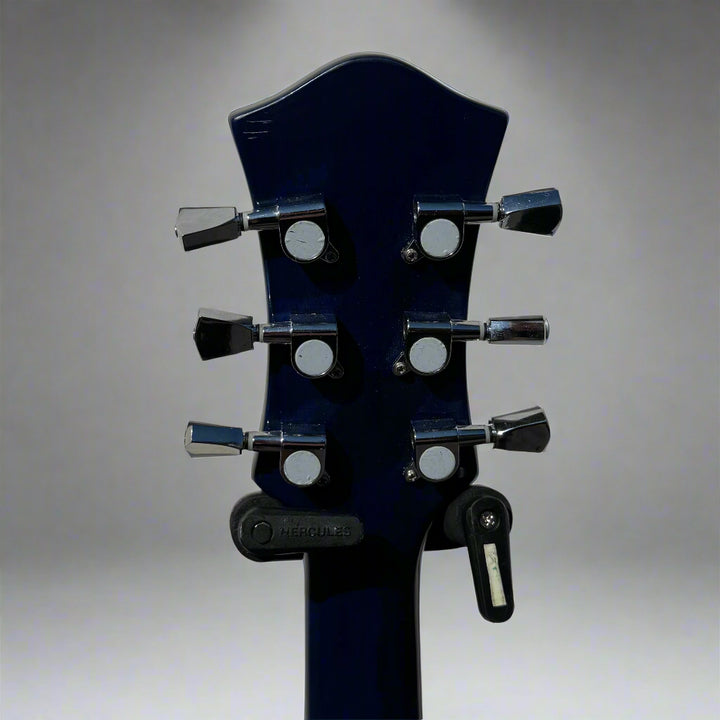 Close-up of a black electric guitar headstock on a light gray background