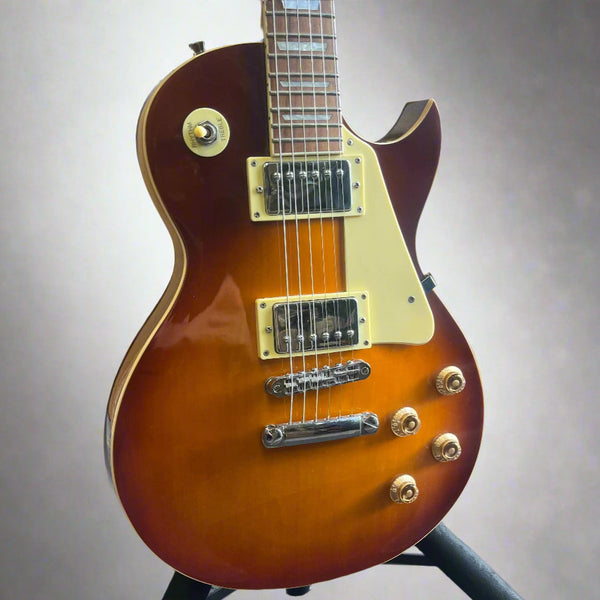Close-up of humbuckers and control knobs on pre-owned Les Paul-style guitar

