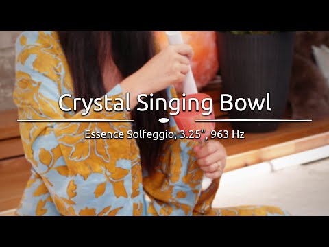 Person playing the 3.25" Essence Solfeggio Crystal Singing Bowl, with sound waves emanating from the bowl.