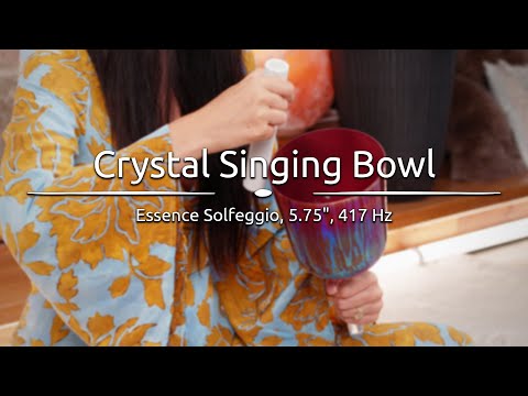  Person playing the 5.75" Essence Solfeggio Crystal Singing Bowl, with sound waves emanating from the bowl.