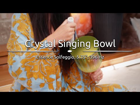 Person playing the 5.75" Essence Solfeggio Crystal Singing Bowl, with sound waves emanating from the bowl.