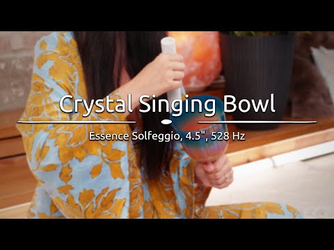 Person playing the 4.5" Essence Solfeggio Crystal Singing Bowl, with sound waves emanating from the bowl.