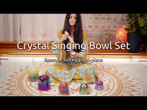 Person playing the Essence Solfeggio Crystal Singing Bowls, with dynamic sound waves visually emanating from the bowls.